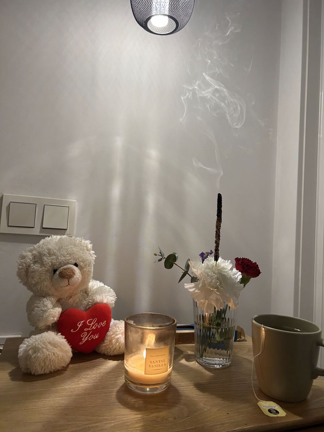 Abend-Ritual am Nachttisch: Kerze, Blumen, Tee und Räucherwerk für besseren Schlaf